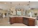 This kitchen island features bar seating, stainless dishwasher, sink, and mosaic backsplash at 3337 Crescent Oaks Blvd, Tarpon Springs, FL 34688