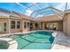 Backyard view of pool at dusk, enclosed with screened patio, and outdoor seating at 3337 Crescent Oaks Blvd, Tarpon Springs, FL 34688