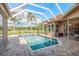 Screened pool area with well-maintained pool, outdoor seating and view to the yard at 3337 Crescent Oaks Blvd, Tarpon Springs, FL 34688