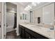 Well-lit bathroom featuring dual sinks, granite countertops, dark cabinetry, and a shower-tub combo at 3532 Wicket Field Rd, Lutz, FL 33548