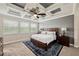 Bedroom featuring a coffered ceiling, a king bed, and large windows for ample natural light at 3532 Wicket Field Rd, Lutz, FL 33548