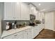 Bright kitchen featuring white cabinets, granite countertops, stainless steel appliances and wood floors at 3532 Wicket Field Rd, Lutz, FL 33548