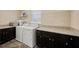 Laundry room featuring dark cabinetry, granite countertops, a window, and a washer and dryer at 3532 Wicket Field Rd, Lutz, FL 33548