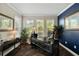 Well-lit home office with a stylish desk, plants, and dark blue accent wall at 3532 Wicket Field Rd, Lutz, FL 33548