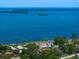 Expansive aerial view showcases waterfront property with lush landscaping and bay views at 43 Edgewater Dr, Dunedin, FL 34698
