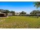 Spacious backyard with mature trees and a fenced area at 43 Edgewater Dr, Dunedin, FL 34698