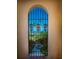 Exterior arched doorway shows lush greenery and a beautiful bay view at 43 Edgewater Dr, Dunedin, FL 34698