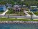 Charming pink two-story home with lush landscaping, located across from the waterfront at 43 Edgewater Dr, Dunedin, FL 34698