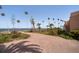 Driveway view of the home surrounded by mature palms and with waterfront views at 43 Edgewater Dr, Dunedin, FL 34698