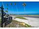 Property's address marker with palm trees and a glimpse of the beautiful waterfront at 43 Edgewater Dr, Dunedin, FL 34698