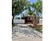Exterior view of a red home with a long driveway and white fence, framed by mature trees at 4634 Iris N St, St Petersburg, FL 33714