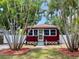 Charming red home with white trim, surrounded by lush palm trees, offering a welcoming curb appeal at 4634 Iris N St, St Petersburg, FL 33714