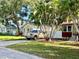 Charming home with mature trees, lush landscaping, and a paved driveway for easy parking at 4634 Iris N St, St Petersburg, FL 33714