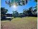 Expansive backyard featuring lush green grass, mature trees, and a covered parking area at 4901 Taylor N St, St Petersburg, FL 33714