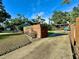 Long concrete driveway with backyard view, wood fence, and car port at 4901 Taylor N St, St Petersburg, FL 33714