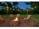 Outdoor fire pit with cushioned chairs on a brick patio surrounded by a grassy yard at 4901 Taylor N St, St Petersburg, FL 33714