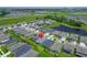 An aerial view of a residential neighborhood with a pond, green spaces, and well-maintained lawns at 5415 Limelight Dr, Apollo Beach, FL 33572