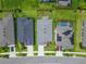 An aerial view of a gray-roofed home with a driveway, and neighboring homes with lush lawns and landscaping at 5415 Limelight Dr, Apollo Beach, FL 33572