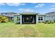 View of the backyard with lush green grass and a screened-in lanai at 5415 Limelight Dr, Apollo Beach, FL 33572
