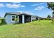 Well-maintained backyard showing the screened-in lanai and lush green lawn at 5415 Limelight Dr, Apollo Beach, FL 33572