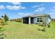 Lush backyard featuring green grass, a screened lanai, and tasteful landscaping at 5415 Limelight Dr, Apollo Beach, FL 33572