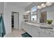 Bathroom with double vanity, granite countertops, white cabinets, and tile flooring at 5415 Limelight Dr, Apollo Beach, FL 33572
