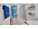 Bright bathroom with tiled walls, neutral tile tub, shower and beach themed decor at 5415 Limelight Dr, Apollo Beach, FL 33572