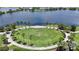 Aerial shot of community green space with palm trees, walking path, and lake in a residential neighborhood at 5415 Limelight Dr, Apollo Beach, FL 33572