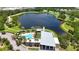 Aerial view of community clubhouse and pool with lake view, palm trees, and manicured lawn at 5415 Limelight Dr, Apollo Beach, FL 33572