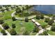 Aerial view of dog park featuring shaded areas, play structures, lush greenery, and a walking path near a pond at 5415 Limelight Dr, Apollo Beach, FL 33572