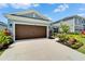 Charming single-Gathering home with a brown two-car garage, beautiful landscaping, and a welcoming entrance at 5415 Limelight Dr, Apollo Beach, FL 33572