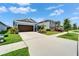 Attractive single-Gathering home with a brown two-car garage, lush landscaping, and a well-manicured lawn at 5415 Limelight Dr, Apollo Beach, FL 33572