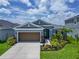 Charming home featuring lush landscaping, a brown garage door, and inviting curb appeal at 5415 Limelight Dr, Apollo Beach, FL 33572