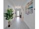 Hallway featuring coastal wall decor and a decorative glass front door with white tile floors at 5415 Limelight Dr, Apollo Beach, FL 33572