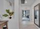 Hallway featuring white tile floors and neutral walls leading to a carpeted bonus room at 5415 Limelight Dr, Apollo Beach, FL 33572