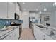 A modern kitchen with stainless steel appliances, white cabinets, granite countertops, and decorative pendant lighting at 5415 Limelight Dr, Apollo Beach, FL 33572