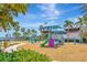 Well-equipped playground featuring climbing structures, slides, and swings, set against a backdrop of palm trees and blue sky at 5415 Limelight Dr, Apollo Beach, FL 33572
