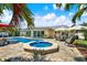 A stunning outdoor oasis features a private pool, spa, patio seating and serene waterfront views at 5473 Bayshore Dr, Seminole, FL 33772