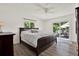 Cozy bedroom with a king size bed, wood floors, ceiling fan, and sliding glass doors to the patio at 5473 Bayshore Dr, Seminole, FL 33772