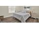Bedroom featuring a queen bed with wood floors, a window with natural light, and side table at 5473 Bayshore Dr, Seminole, FL 33772