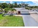 Exterior of home showcasing a well-manicured lawn and long driveway at 5473 Bayshore Dr, Seminole, FL 33772