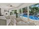 Relaxing living room with ample seating and a view of the pool and landscaped backyard at 5473 Bayshore Dr, Seminole, FL 33772