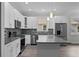 Modern kitchen with white cabinets, stainless steel appliances, gray countertops, and gray backsplash at 5707 N 20Th St, Tampa, FL 33610