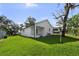 Exterior backyard view, showcasing the lush green lawn and tree lined boundary at 5709 N 20Th St, Tampa, FL 33610
