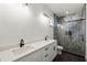 This modern bathroom features dual vanity sinks, an enclosed tiled shower, and a window for natural light at 5709 N 20Th St, Tampa, FL 33610