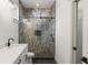 This modern bathroom features a glass enclosed shower, stylish tile, black accents and a single sink vanity at 5709 N 20Th St, Tampa, FL 33610
