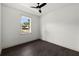 This bedroom features fresh white walls, a window providing natural light, dark wood-style flooring and a ceiling fan at 5709 N 20Th St, Tampa, FL 33610