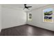 Bedroom with dark wood-look floors, neutral walls, and ample natural light from the windows at 5709 N 20Th St, Tampa, FL 33610