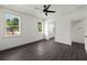A bedroom boasts dark wood flooring, crisp white trim, neutral walls, two windows and an ensuite bathroom at 5709 N 20Th St, Tampa, FL 33610