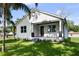 Charming white home with inviting front porch, black trim accents, and fresh landscaping on a sunny day at 5709 N 20Th St, Tampa, FL 33610